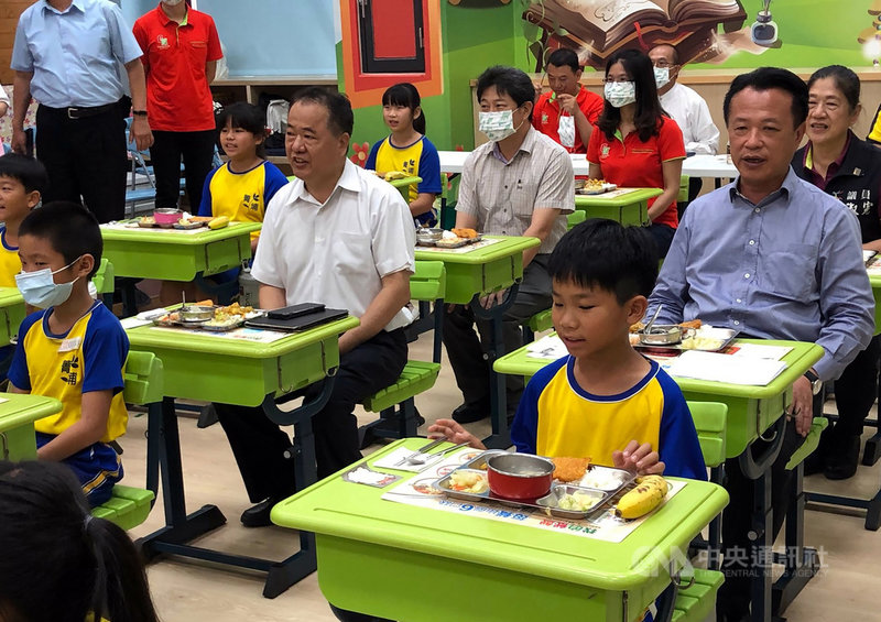 漁業署22日在嘉義縣菁埔國小舉辦國產文蛤偏鄉中小學推廣活動，漁業署長張致盛（2排右2）與嘉義縣長翁章梁（2排右）出席，並與學童一起享用午餐。中央社記者黃國芳攝　110年4月22日