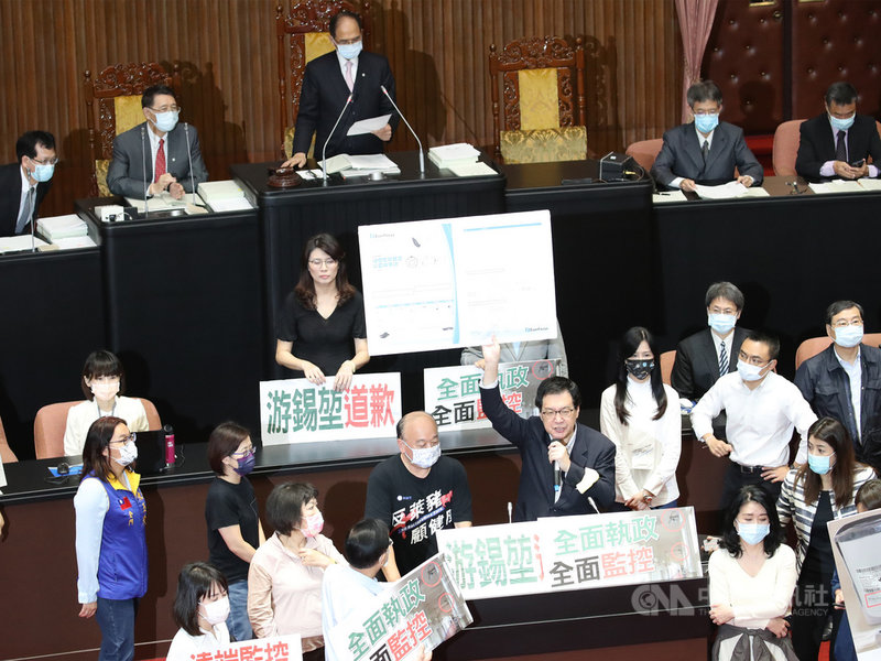 立法院23日上午召開院會,國民黨立委占領發言台要求處理權宜問題,黨團總召費鴻泰(前排,手舉看板者)主張立法院長游錫堃(後左3)應道歉並說明為何要裝監視器、對在野黨立委做政治偵防。中央社記者張新偉攝 110年4月23日