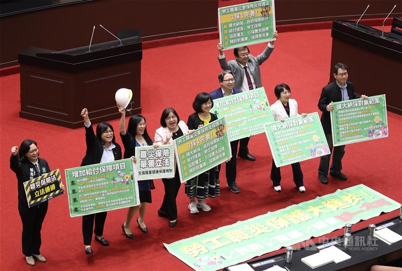 立法院會23日三讀通過勞工職業災害保險及保護法,除擴大納保範圍、增加給付金額,也將職災保護及預防明文入法,並強化職災預防、重建及傷病通報業務。法案三讀後,朝野立委開心拿著看板留影。中央社記者張新偉攝 110年4月23日