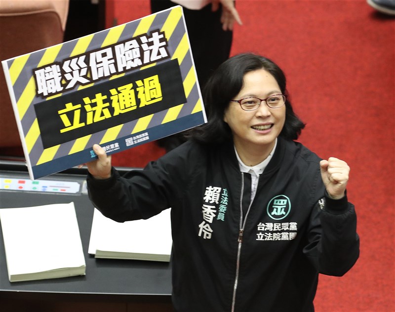 趕在五一勞動節前夕,立法院會23日下午三讀通過勞工職業災害保險及保護法,擴大納保範圍、增加給付金額,也將職災保護及預防明文入法。民眾黨立委賴香伶在立法通過後,開心拿起看板合影。中央社記者張新偉攝 110年4月23日