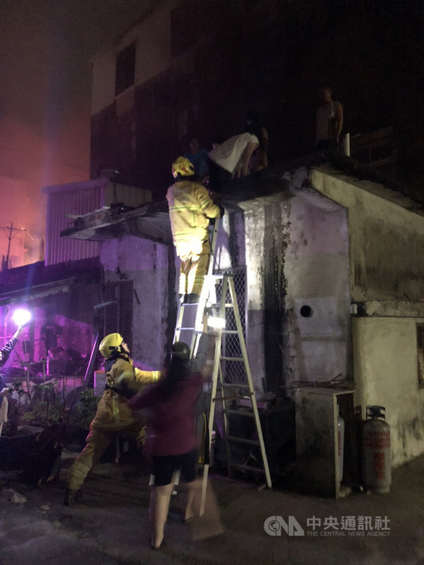 高雄路竹區新生路28日凌晨2時許發生一起火警,4層建築物自1樓竄出濃煙,消防局出動人車前往搶救,幸因鄰房為一層樓建築,屋內7人攀爬到鄰房頂樓平台逃生順利脫困。(高雄市消防局提供)中央社記者王淑芬傳真 110年4月28日