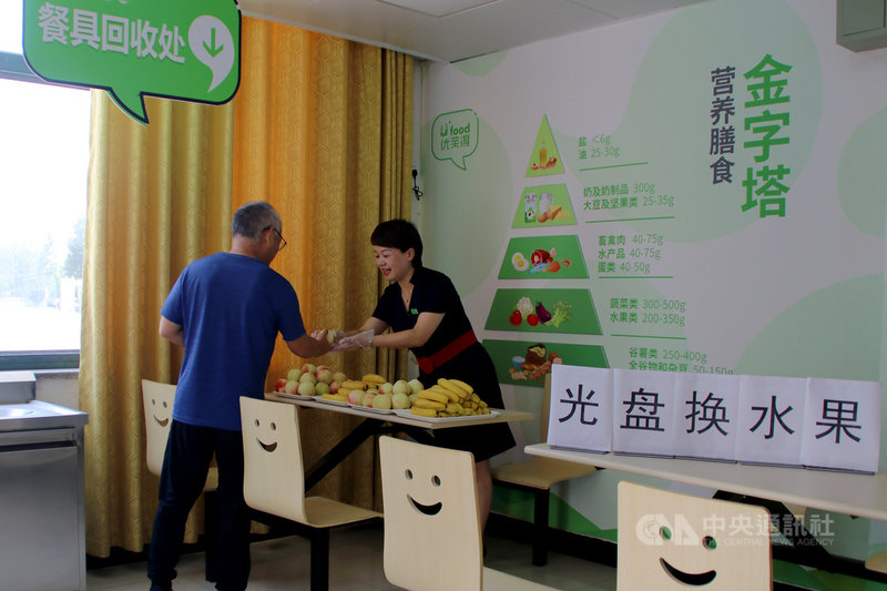 中國人大常委會29日通過「反食品浪費法」，明定若消費者點餐浪費，業者可收廚餘垃圾處理費。圖為去年8月28日，安徽省肥西縣一個機關餐廳裡，工作人員用吃乾淨的「光盤」換水果。（中新社提供）中央社　110年4月29日