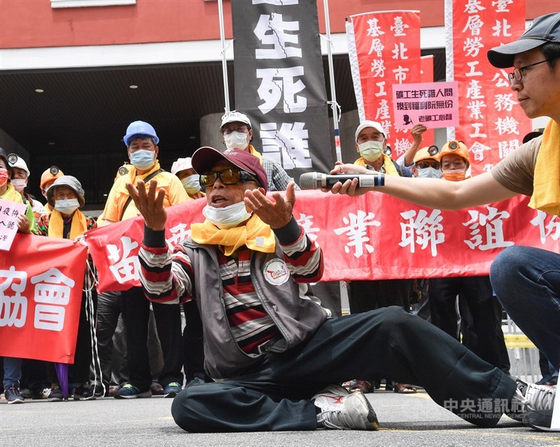 一年一度五一勞工大遊行1日中午登場，超過百名老礦工今年也加入遊行，他們先在立法院群賢樓前集結表訴求，一名老礦工趴地模擬當年工作環境，呼籲政府積極照顧老礦工的老年生活。中央社記者鄭清元攝 110年5月1日