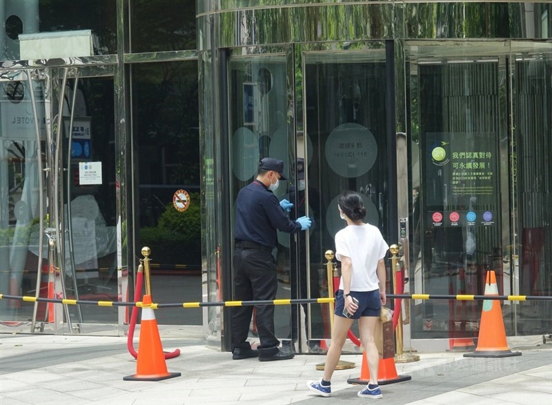 諾富特飯店外包商確診,飯店環境採檢432件,全數檢體陰性,感染途徑待釐清。圖為諾富特1日淨空,保全人員將出入大門鎖上。(中央社檔案照片)