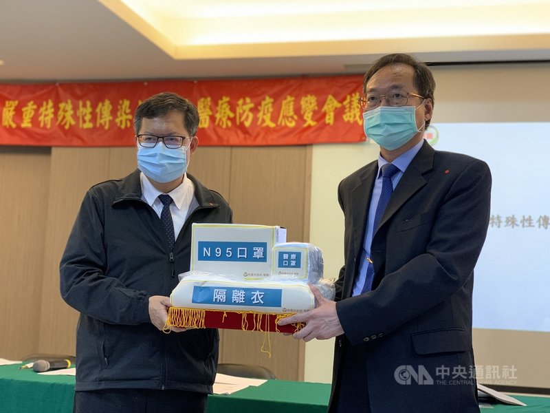 桃園市長鄭文燦(左)4日頒發市府向中央爭取的防疫物資給桃園市醫師公會理事長莫振東(右)。中央社記者葉臻攝 110年5月4日