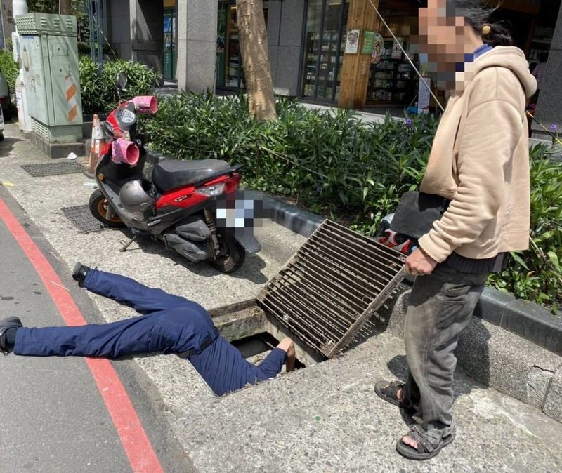 基隆一名男子日前不慎將祖傳戒指掉到水溝內,第二警分局信義派出所所長徐紹文到場後,趴在高溫的地面往水溝涵洞查看,手持通槍條將戒指勾出,男子取回後感謝警方熱心協助。(讀者提供)中央社記者王朝鈺傳真 110年5月4日