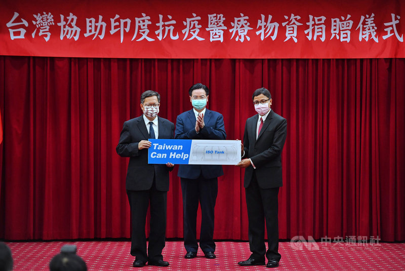 台灣協助印度抗疫醫療物資捐贈儀式5日在外交部舉行,在外交部長吳釗燮(中)出席見證下,捐贈方代表、桃園市長鄭文燦(左)象徵性將物資交付給印度台北協會會長戴國瀾(Gourangalal Das)(右)。中央社記者王飛華攝 110年5月5日