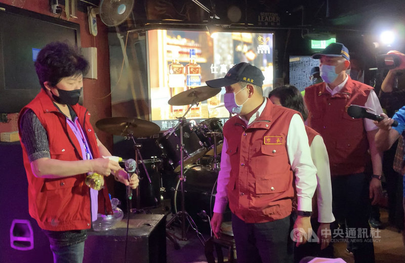 新北市長侯友宜(前右)5日帶隊稽查三重區一棟複合式大樓,了解大樓內各空間公安及防疫情形。在視察一家KTV時,現場工作人員示範如何為麥克風消毒。中央社記者沈佩瑤攝 110年5月5日