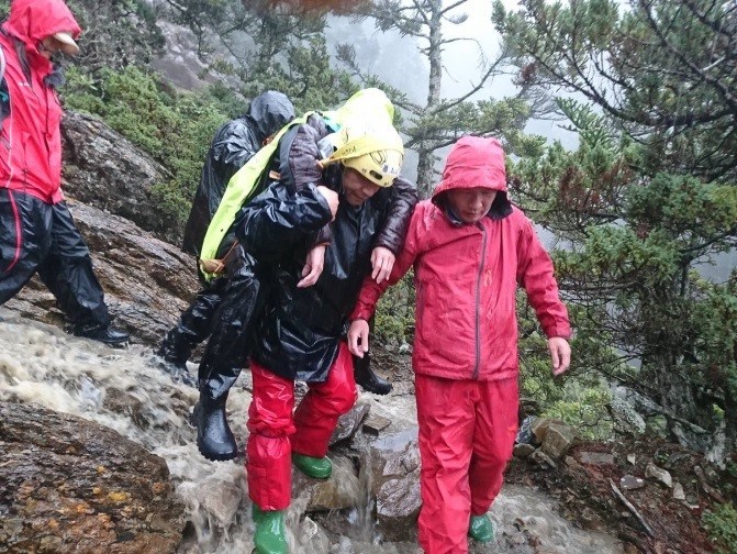行政院核定,玉山、陽明山、太魯閣及雪霸國家公園約僱保育巡查員每人每月最高加薪3300元。圖為保育巡查員揹病患下山。(圖取自內政部網頁moi.gov.tw)