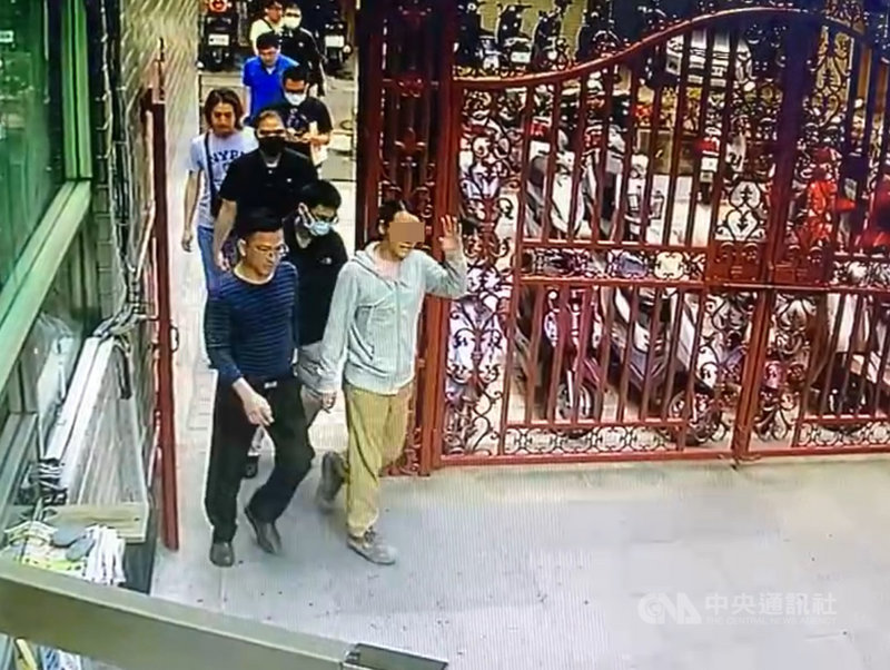 台中市阮姓男子(前右)被控在祖父過世後,偽造簽名將房屋及土地過戶至他名下。他的祖母無故失蹤,檢警在阮男住處發現疑似祖母牙齒關鍵證物。搜捕畫面7日曝光,阮男落網時神色泰然,離開社區還向警衛揮手致意。(民眾提供)中央社記者趙麗妍傳真 110年5月7日
