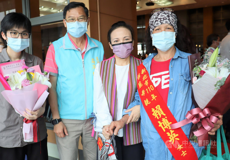 新北市政府原住民族行政局7日表示,阿美族賴博英(右1)撫養自己的2名子女與姊姊的3個孩子,還要照顧癱瘓的先生,日前獲市府表揚為模範母親,原民局長羅美菁(右2)贈花致意。(原民局提供)中央社記者黃旭昇新北傳真 110年5月7日