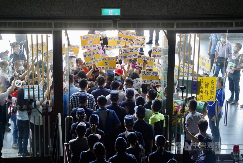 高雄市議會7日上午進行「高雄市環境污染防治作為」專案報告,民間團體「反空污反萊毒顧健康全民聯盟」到場外陳情,喊話要市長陳其邁出面,還作勢衝入議會遞交陳情書,但被警方攔下。中央社記者董俊志攝 110年5月7日