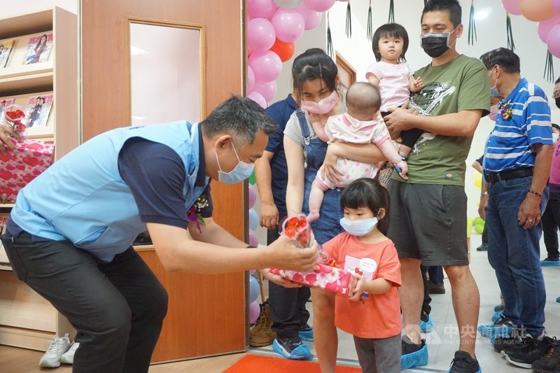 金門第2家公辦民營托嬰中心7日揭牌,縣長楊鎮浯(左)和家長帶領小朋友走聰明門,象徵過了聰明門,寶寶聰明、長大學習順利;楊鎮浯並致贈禮物給小朋友。中央社記者黃慧敏攝 110年5月7日
