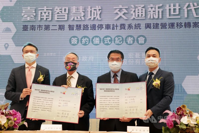 在台南市長黃偉哲(右2)和宏碁集團創辦人施振榮(左2)見證下,台南市政府交通局長王銘德(右)和宏碁智通公司董事長陳俊聖(左)7日簽定「台南市第二期智慧停車計費系統BOT案」,預定再建置2000席智慧停車格位。(台南市政府提供)中央社記者張榮祥台南傳真 110年5月7日
