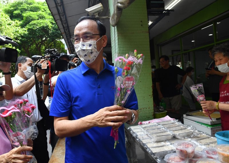 國民黨8日在台北內湖傳統市場舉辦「寵愛媽咪、響應828公投」活動,前國民黨主席朱立倫(中)出席,向民眾分送康乃馨。中央社記者王飛華攝 110年5月8日