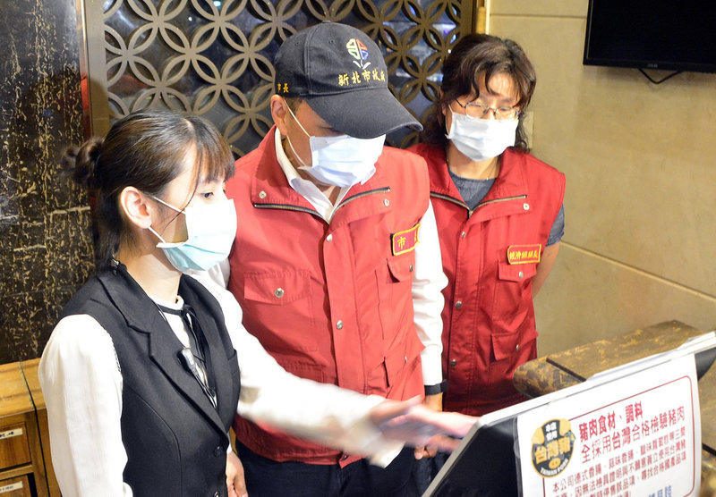 國內疫情急遽升溫,新北市長侯友宜(中)12日公告新北市10類娛樂營業場所即日起強制暫停營業,侯友宜晚間前往板橋區星聚點KTV訪視,到櫃台區了解電腦取消訂位狀況。中央社記者黃旭昇新北市攝 110年5月12日