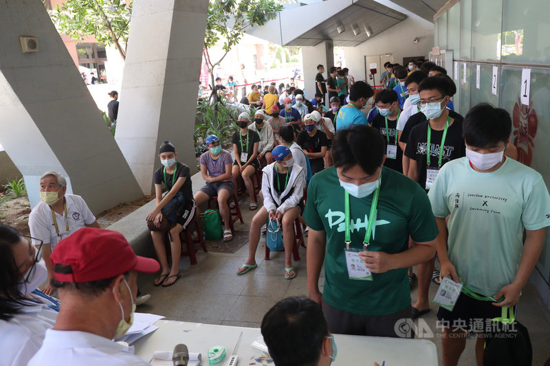 中央流行疫情指揮中心11日將疫情警戒升級至第2級,全大運12日各項防疫措施也跟著升級,立即啟動人流控管,嚴格控制比賽場地室內100人以下、室外500人以下的規定。圖為選手們在游泳池外進行檢錄。中央社記者吳家昇攝 110年5月12日