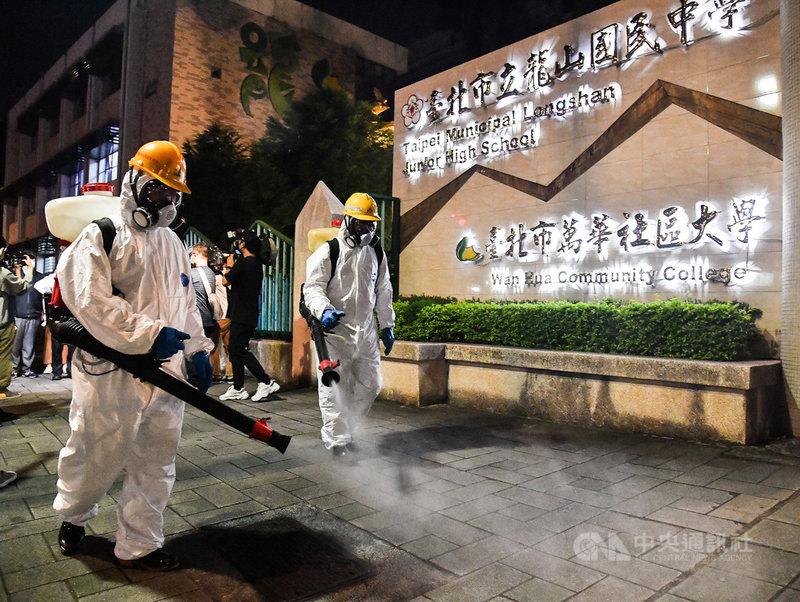 台北市環保局人員13日晚間在龍山國中周邊進行例行性防疫消毒作業，針對學校外圍人行道全面消毒，盼提供民眾安心無虞的公共空間。中央社記者鄭清元攝　110年5月13日