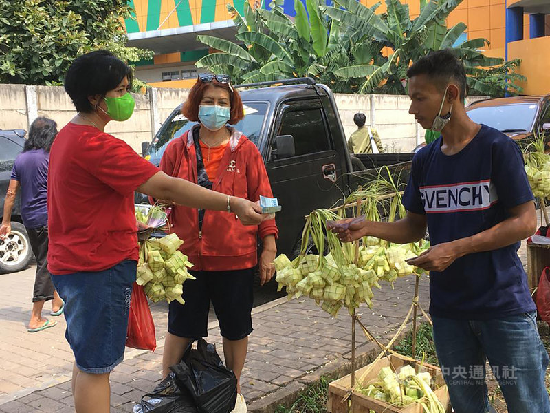 印尼穆斯林慶祝開齋節會與親友享用印尼粽Ketupat,彼此原諒對方過錯。圖為民眾10日在雅加達瑟南市場外購買粽囊。中央社記者石秀娟雅加達攝 110年5月13日