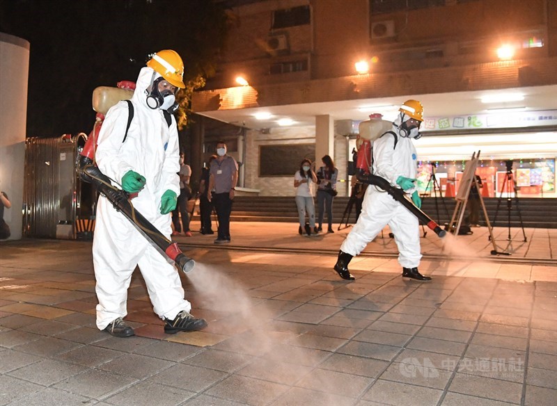 台北市萬華區龍山國中周邊一帶13日晚間由環保局人員執行例行性防疫消毒作業，作業人員皆全副武裝，沿途仔細噴消。台北市長柯文哲也到場視察消毒過程。中央社記者鄭清元攝　110年5月13日