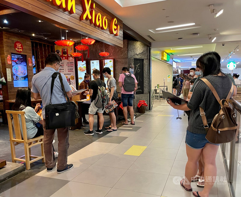 新加坡16日起將禁止餐廳內用,以防止疫情擴大。圖為14日晚間當地一處商場內,許多民眾排隊等著要在餐廳用餐。中央社記者侯姿瑩新加坡攝 110年5月14日