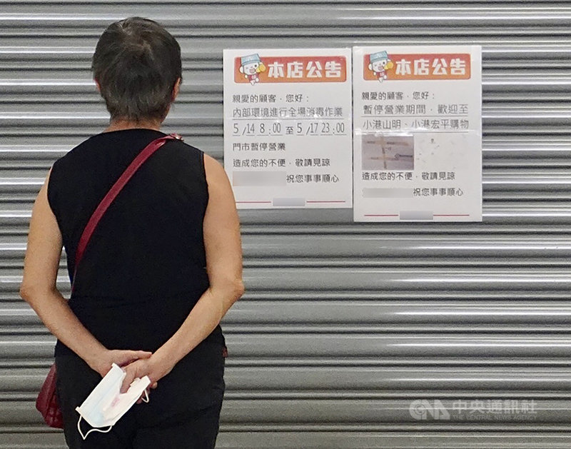 高雄市14日首度出現與獅子會群聚案相關確診個案,為案1229的30多歲女兒(案1289);案1289確診後,高市府也對小港區某健身房及超市進行消毒。圖為民眾在賣場外觀看門上張貼的暫停營業公告。中央社記者董俊志攝 110年5月14日