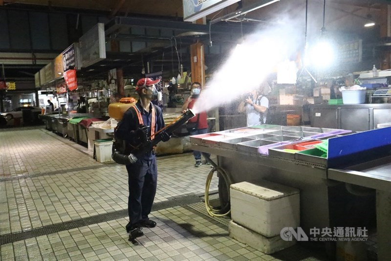 高雄市長陳其邁16日公布防疫再加嚴,針對夜市、市場全面禁止內用,改採外帶食物。圖為工作人員14日晚間到苓雅區武廟市場全面噴消。(中央社檔案照片)
