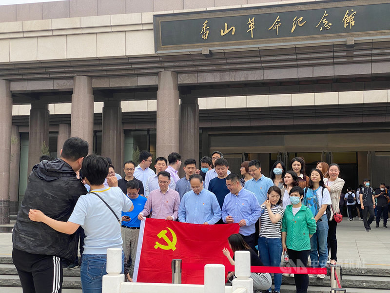 時值中共百年黨慶,北京香山革命紀念館人潮紛至沓來,從國家機關到小學生,可謂「黨政軍民學」全動員。圖為手持中共黨旗合影的參訪機關團體。中央社記者繆宗翰北京攝 110年5月16日