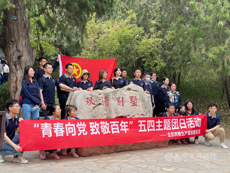 時值中共百年黨慶,位於北京香山的雙清別墅「紅色景點」人潮紛至沓來。圖為手持共青團旗幟合影的參訪企業團體。中央社記者繆宗翰北京攝 110年5月16日