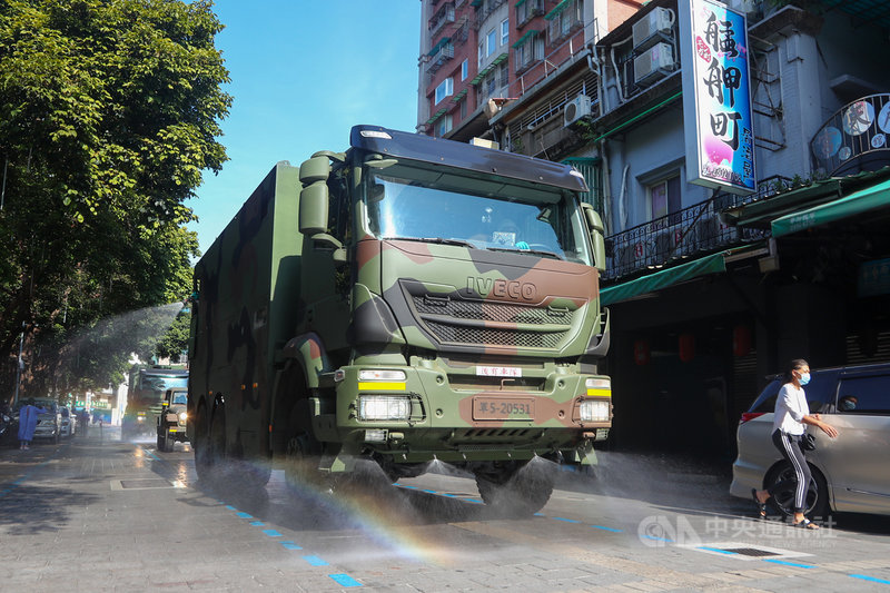 國軍33化學兵群16日一早出動車隊支援台北市萬華區全區第二波大消毒,車隊沿著大街小巷仔細消毒。中央社記者王騰毅攝 110年5月16日