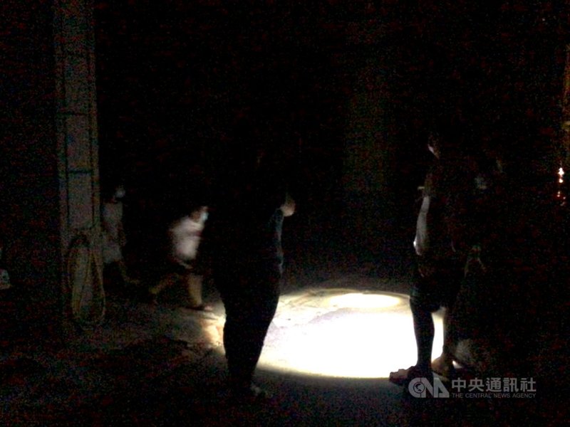 17日下午至今用電量持續攀升,全台再次分區限電。高雄部分地區晚間停電,由於天氣炎熱,不少居民走出家門,民眾不忘戴口罩防疫。中央社記者侯文婷攝 110年5月17日