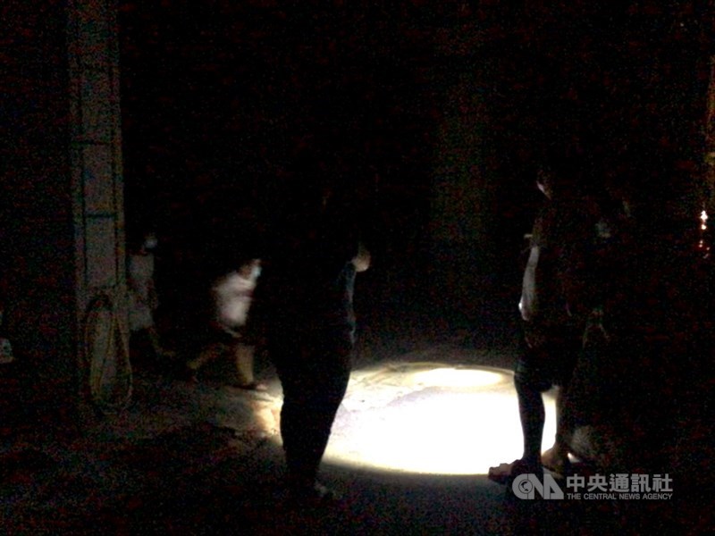 17日下午至今用電量持續攀升,全台再次分區限電。高雄部分地區晚間停電,由於天氣炎熱,不少居民走出家門,民眾不忘戴口罩防疫。中央社記者侯文婷攝 110年5月17日