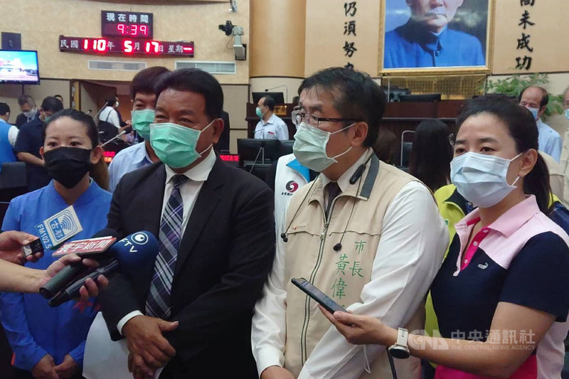 台南市議會17日原定進行市政總質詢,議長郭信良(前左2)在開議時宣布,因武漢肺炎(2019冠狀病毒疾病,COVID-19)疫情升溫,經政黨協商後,延到28日再開議。台南市長黃偉哲(前右2)表示,市府將會全力投入抗疫工作。中央社記者楊思瑞攝 110年5月17日