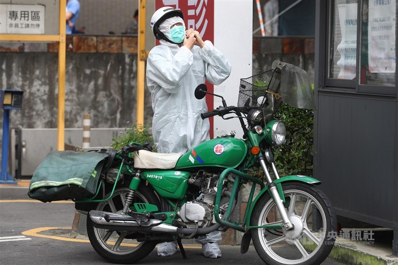 國內疫情延燒,新北市板橋區亞東醫院爆發院內傳染案件,一名郵局的郵務士17日到亞東醫院送件時換上防護衣,加強防疫。中央社記者王騰毅攝 110年5月17日
