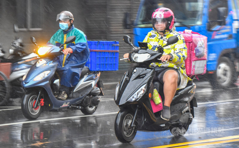 疫情升溫,民眾減少外出,外送的需求增加,台北市18 日午後突降下大雨,外送業者在雨中接單送貨。中央社記者鄭清元攝 110年5月18日