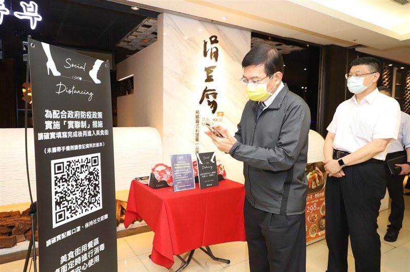 交通部長王國材(左)19日下午到台北車站視察台鐵、高鐵及車站商場各項防疫工作,及「簡訊實聯制」導入雙鐵的進度,並親自掃描QR Code操作與測試。(交通部提供)中央社記者汪淑芬傳真 110年5月19日