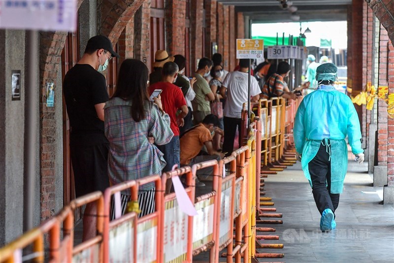 中央流行疫情指揮中心指揮官陳時中22日表示,目前台北市萬華區及周邊熱區篩檢陽性率都沒有再升高,這2天已經維持平穩。圖為19日萬華區剝皮寮快篩站民眾牌等候篩檢。(中央社檔案照片)