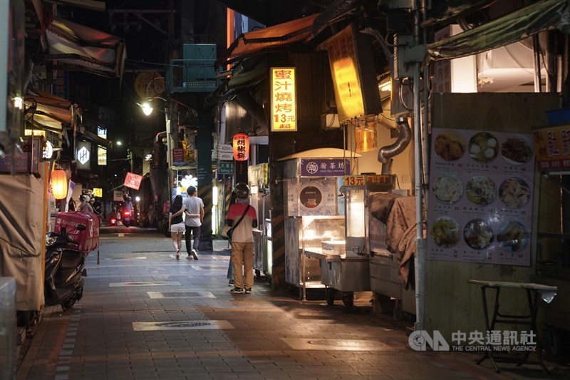 少數業者點燈開店，外送員在旁等候領取顧客所訂餐點。中央社記者徐肇昌攝 110年5月22日