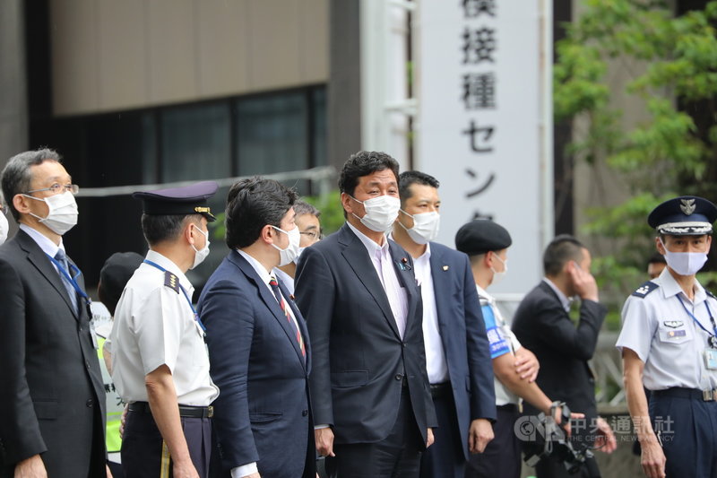日本政府在東京與大阪各設一處大規模疫苗接種中心,24日開始施打,由自衛隊負責疫苗施打的作業。圖為防衛大臣岸信夫(中)在東京會場迎接日本首相菅義偉前來視察。中央社記者楊明珠東京攝 110年5月24日
