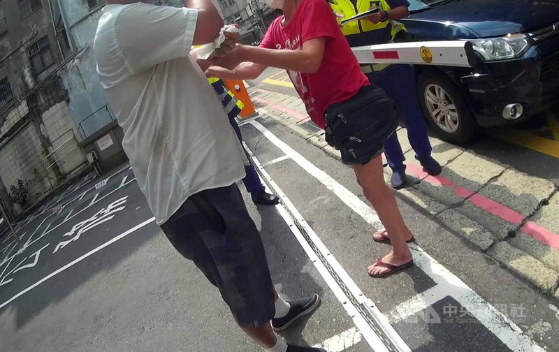 台北市一名男子(左)23日外出未戴口罩且看見警方就逃逸,因驚慌腿軟而不慎被鐵鍊絆倒,路過員警上前關心和攙扶,隨後到場親友也勸導未果,警方依法送辦裁罰。(翻攝照片)中央社記者黃麗芸傳真 110年5月24日
