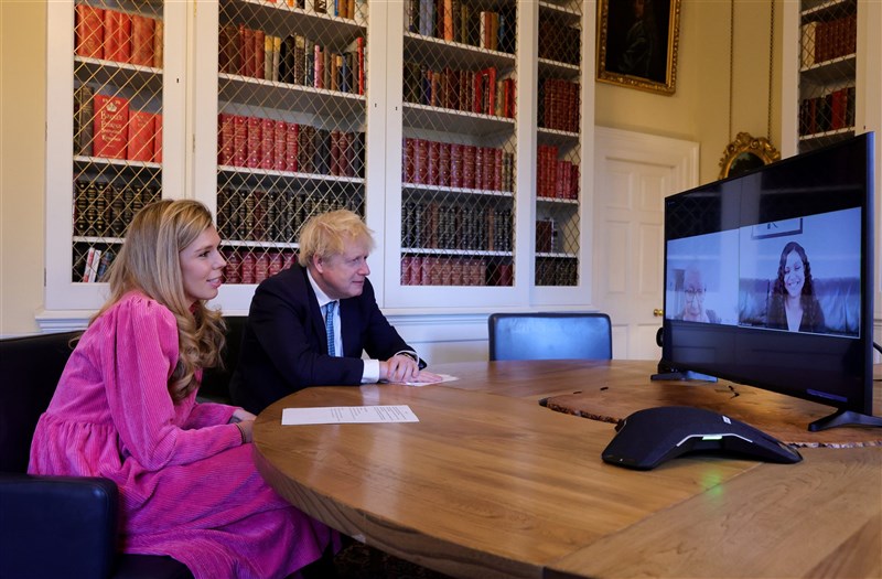 英國首相強生(左2)和未婚妻席孟茲(左1)寄送喜帖給親朋好友,預定2022年7月30日舉行婚禮。圖為兩人先前與「一起過耶誕」活動人員視訊。(圖取自twitter.com/BorisJohnson)