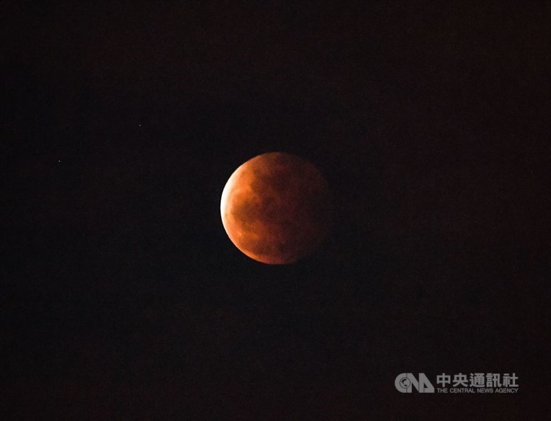 天文景觀月全食26日晚間登場,適逢年度最大滿月,夜空中可見暗紅色月面。中央社記者鄭清元攝 110年5月26日