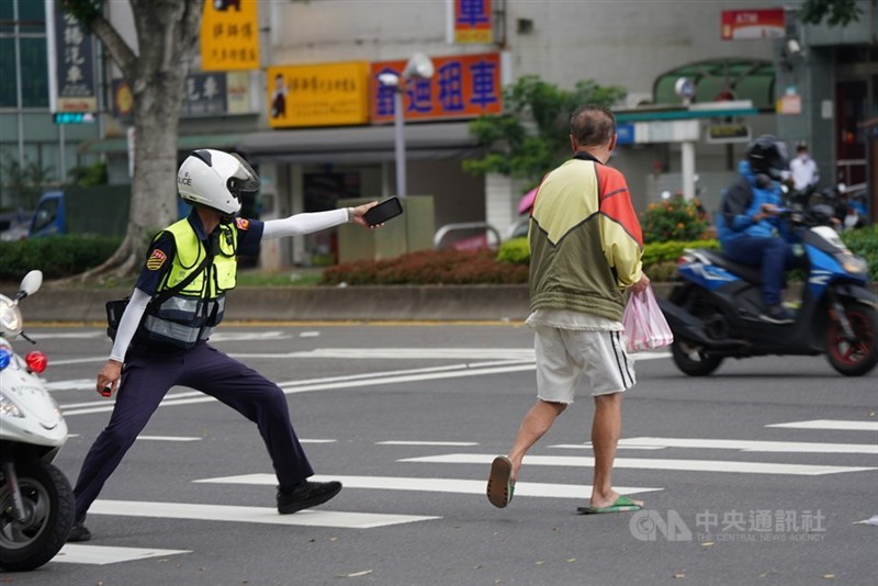 指揮中心副指揮官陳宗彥26日表示,全台有5萬名警消列在前3優先疫苗施打順位。圖為一名員警20日在北市街頭巡邏時,看見沒戴口罩的民眾,進行攔檢勸導。(中央社檔案照片)