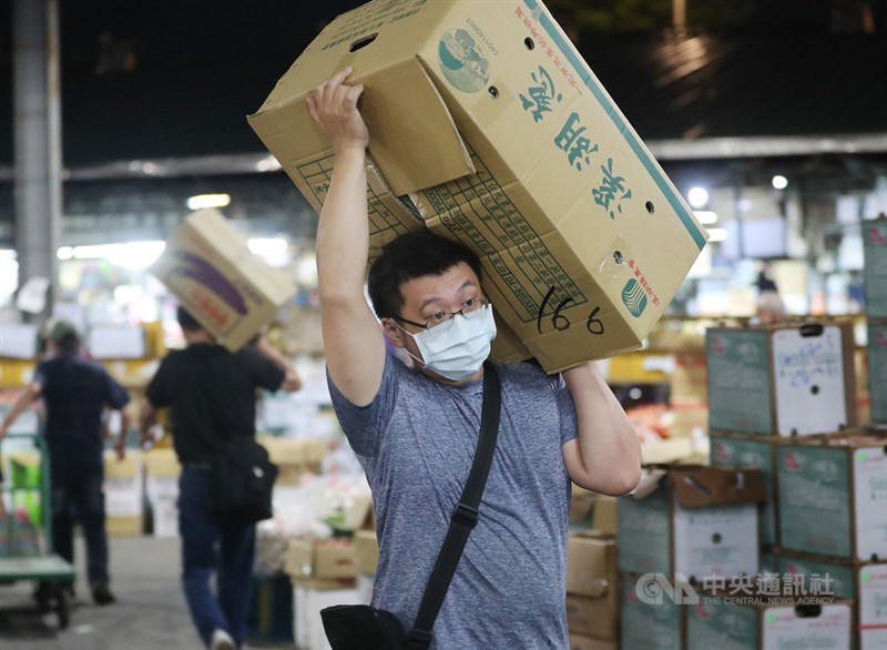 台北農產運銷公司是國內蔬菜運銷重要樞紐，在第一果菜批發市場的工作人員，無論是供應單位、承銷業者皆配戴口罩在現場完成拍賣工作。中央社記者張皓安攝 110年5月26日