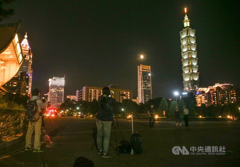 天文奇景「超級血月」（Super Blood Moon）26日晚間登場，有攝影迷到國父紀念館觀測難得一見的天文景觀。中央社記者謝佳璋攝　110年5月26日