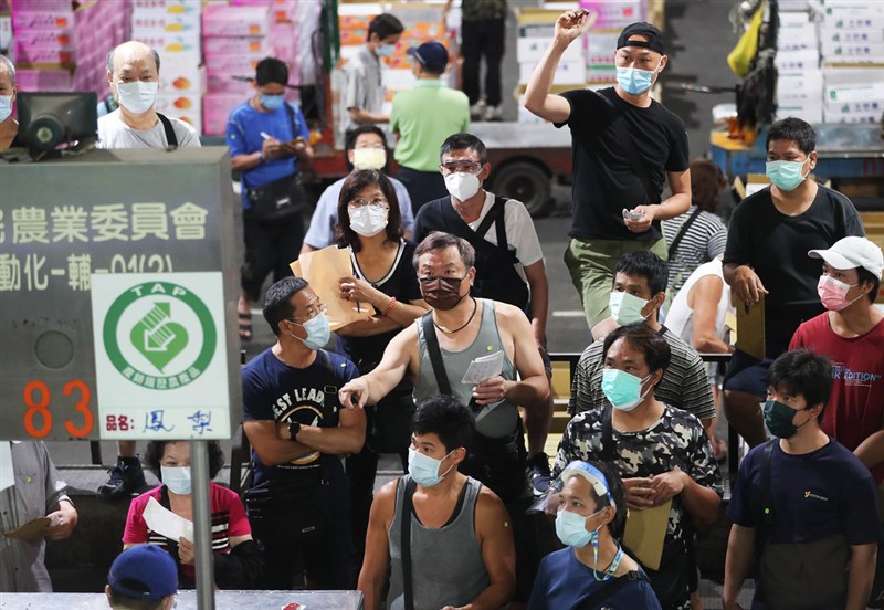 台北農產運銷公司負責提供民生必需品，員工無法在家上班，北農將拍賣區域拉大，拍賣機台距離也再加大，同時嚴格執行全程戴口罩。中央社記者張皓安攝 110年5月26日