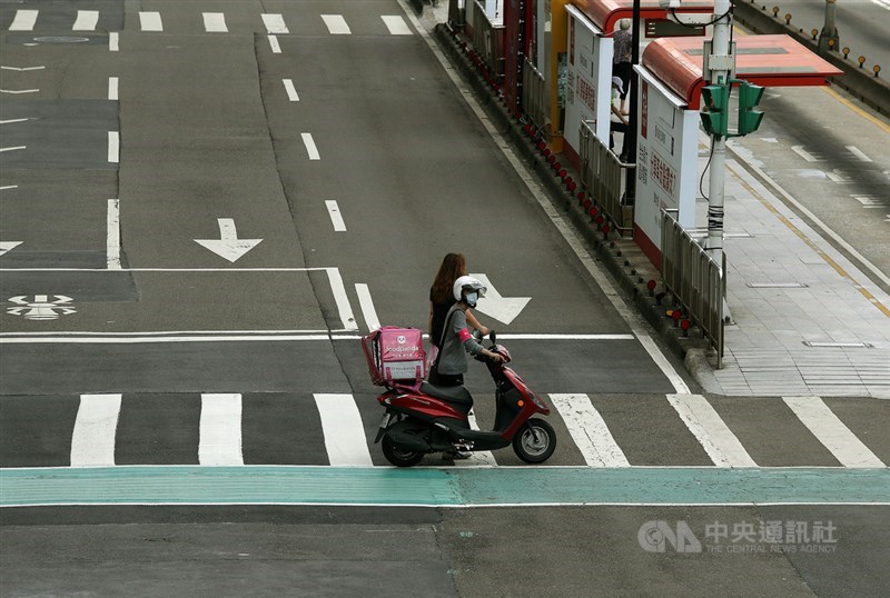 疫情三級疫情警戒，街上人潮銳減，不少外送員仍是大街小巷穿梭，努力跑單為居家民眾服務。中央社記者郭日曉攝 110年5月23日