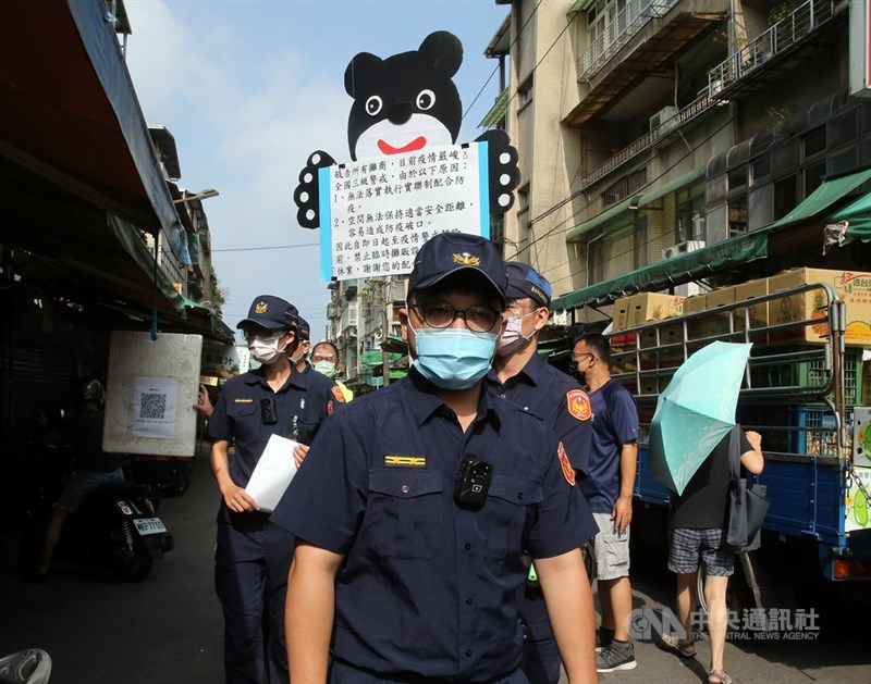 文山區木新市場天天有人潮聚集，議員擔心非列管的攤販市集成為防疫破口，要求北市府宣布暫停非民生所需業者擺攤。26日分局員警出動到現場勸導並取締違規攤販。中央社記者郭日曉攝 110年5月26日