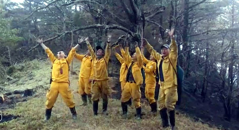 23日午後一場陣雨協助森林護管員控制火勢，讓辛苦多日的他們歡欣鼓舞。（嘉義林管處提供）