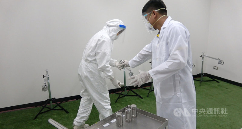 泰國朱拉隆功大學訓練拉布拉多犬利用靈敏的嗅覺,分辨出誰是武漢肺炎的潛在患者。圖為工作人員將受檢人的汗水樣本放入裝置內,準備讓犬隻嗅聞。中央社記者呂欣憓曼谷攝 110年5月27日
